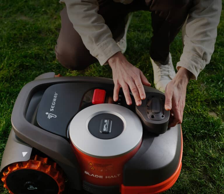 Technicien AP Robots réalisant l'entretien professionnel d'un robot tondeuse Segway Navimow - Service de maintenance expert garantissant les performances optimales et la longévité des tondeuses.