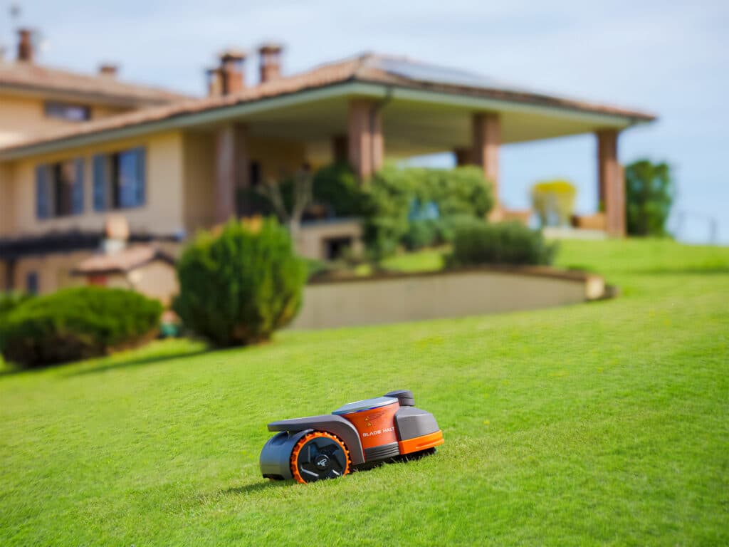 Robot tondeuse Segway Navimow série H gravissant avec aisance une pente de jardin à 45° - Technologies de traction avancées d'AP Robots garantissant performance et sécurité sur terrains inclinés.