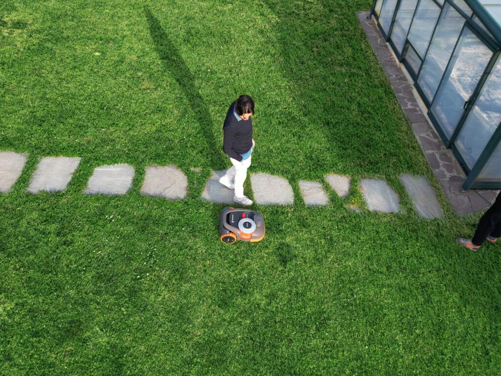 Vue aérienne d'un grand jardin avec le robot Navimow série H créant des motifs de tonte parfaits - Solution automatisée idéale pour les propriétaires de grands espaces verts exigeant une finition professionnelle.