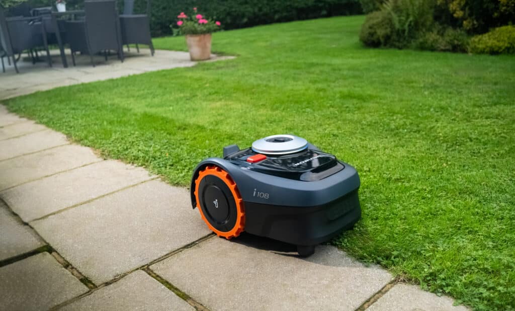 Robot tondeuse Segway Navimow i108 intégré harmonieusement dans un jardin familial - Solution automatisée idéale pour profiter pleinement des espaces verts sans contrainte d'entretien.
