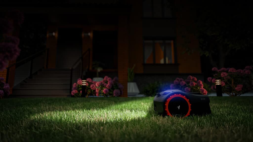 Robot tondeuse Segway Navimow i108 illuminé de nuit dans un jardin - Mise en valeur des LED et du design futuriste de cette tondeuse autonome fonctionnant 24h/24, démontrant l'innovation technologique d'AP Robots même dans l'obscurité.
