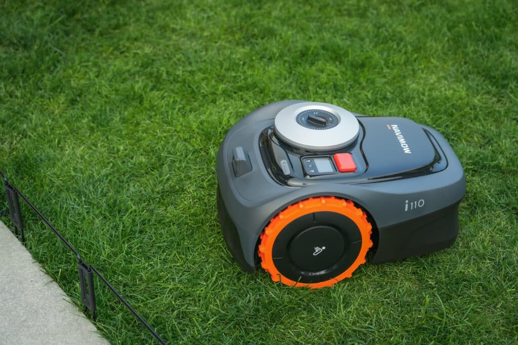 Robot tondeuse Segway Navimow i108 intégré harmonieusement dans un jardin familial - Solution automatisée idéale pour profiter pleinement des espaces verts sans contrainte d'entretien.